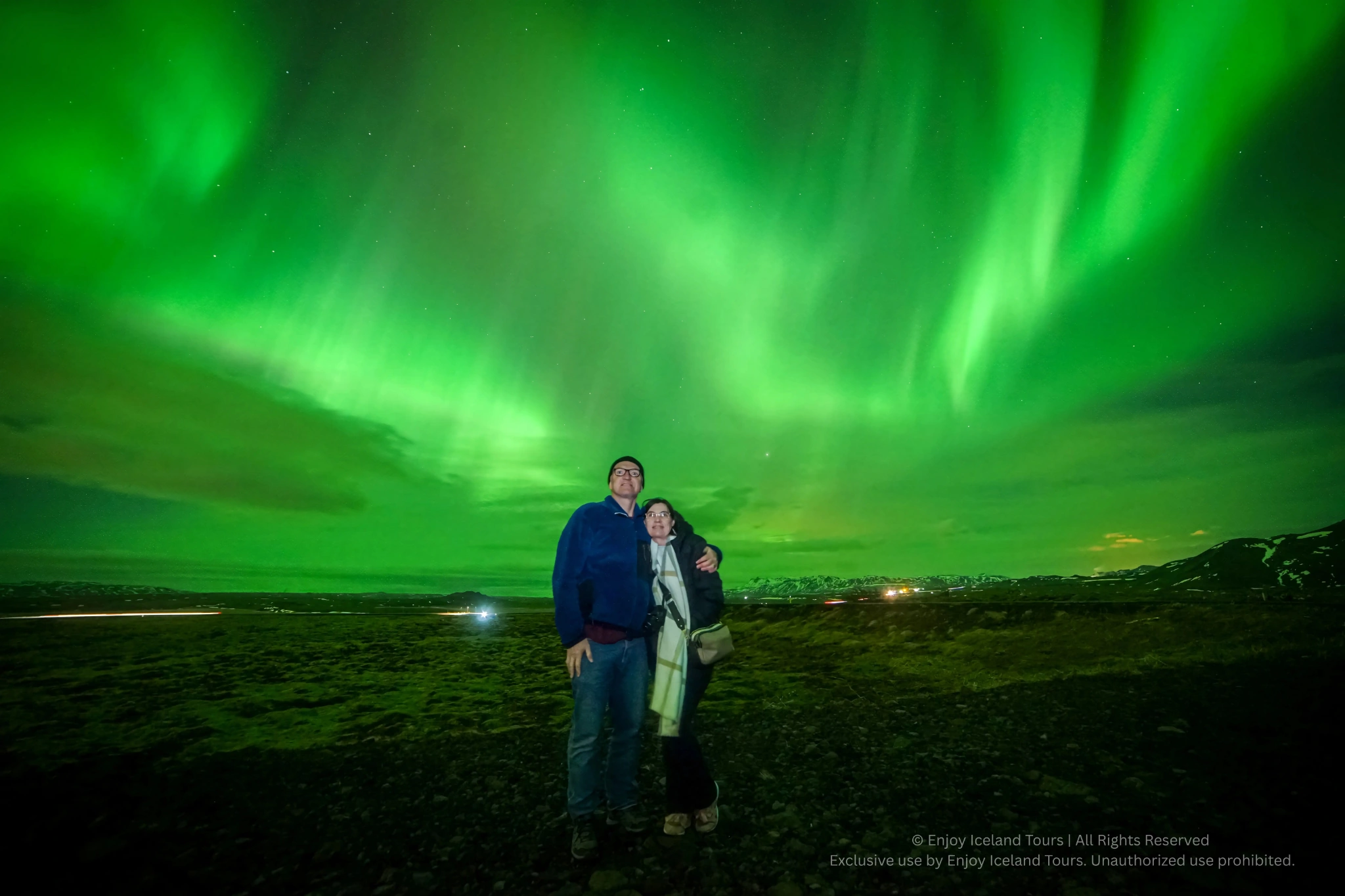 Couple watching the Northern Lights from Reykjavik