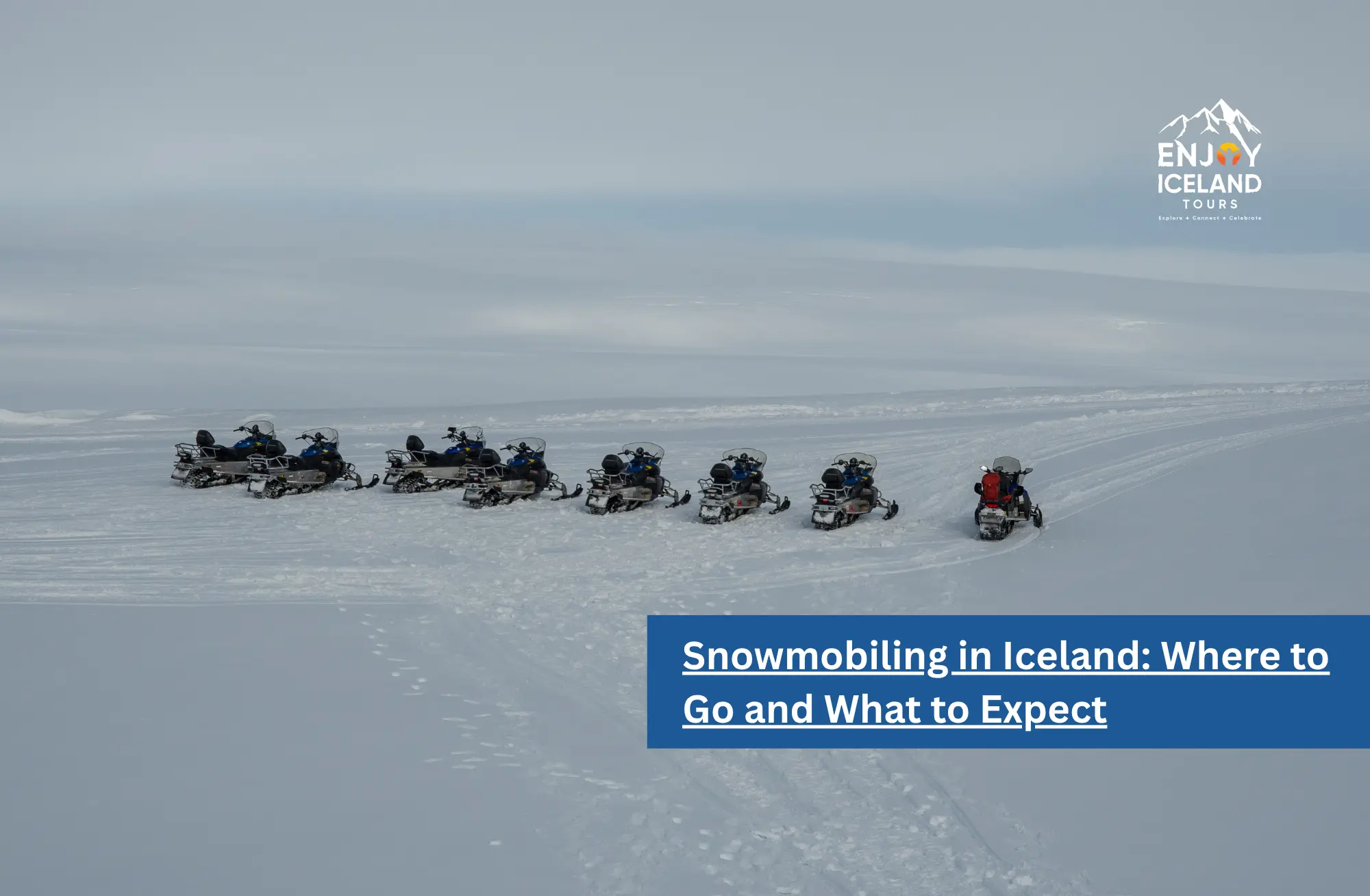 Line of snowmobiles parked on a snow-covered glacier in Iceland under a pale winter sky